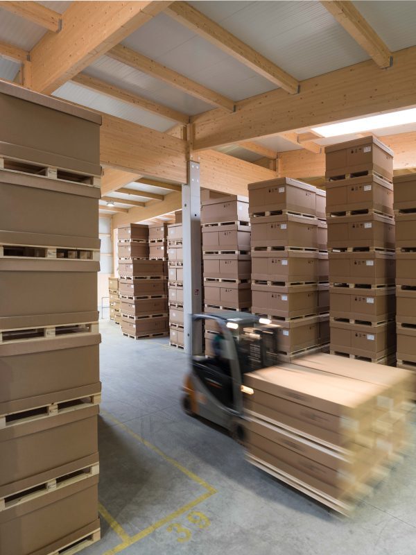 Lagerhalle mit gestapelten Kartons und Verpackungsmaterialien