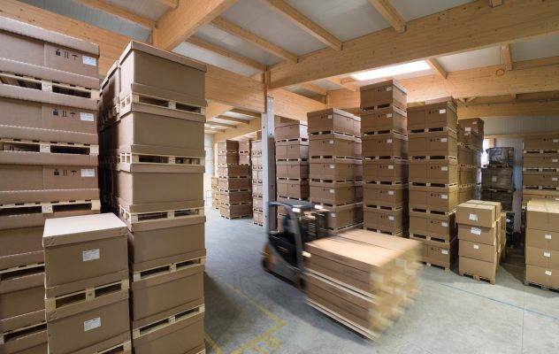 Lagerhalle mit gestapelten Kartons und Verpackungsmaterialien