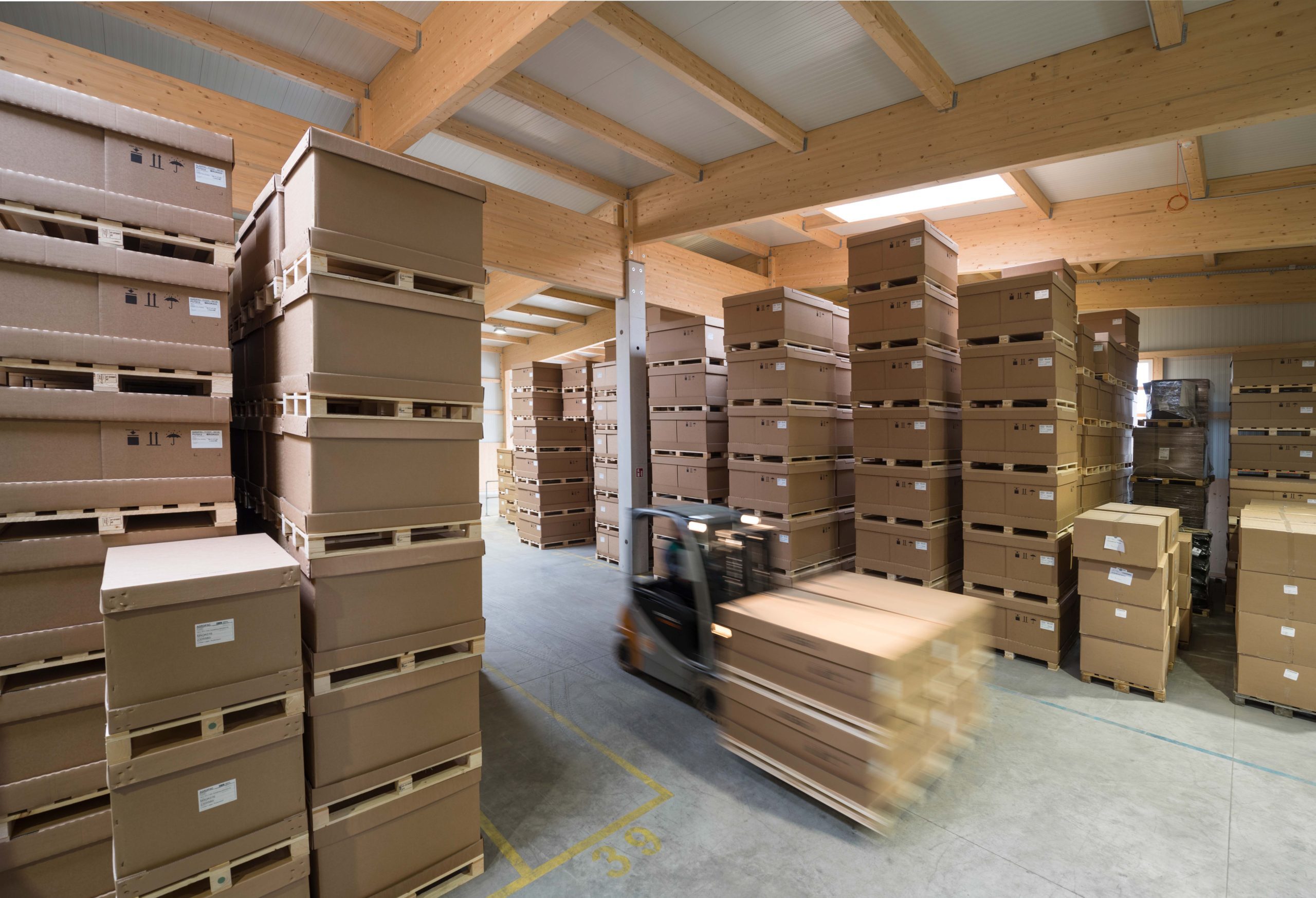 Lagerhalle mit gestapelten Kartons und Verpackungsmaterialien