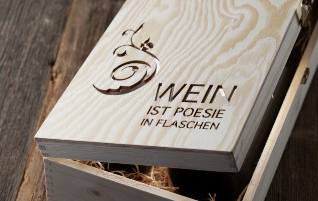 Holzkiste mit der Gravur „Wein ist Poesie in Flaschen“