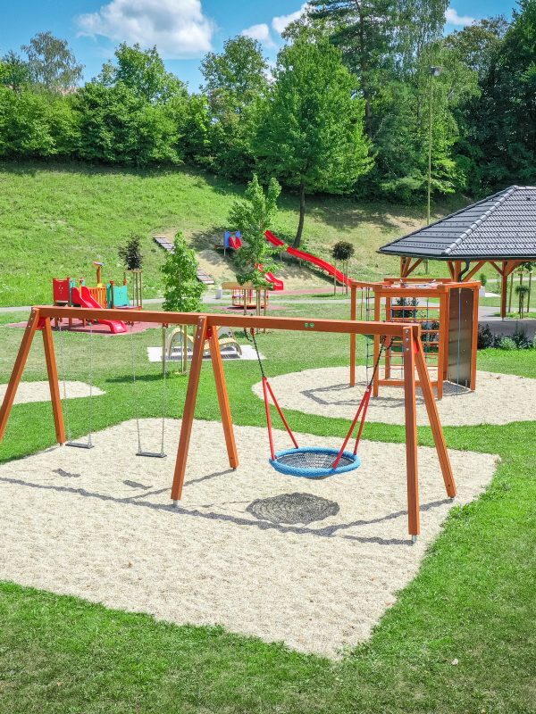 Schaukelanlage mit mehreren Sitzen auf einer Grünfläche